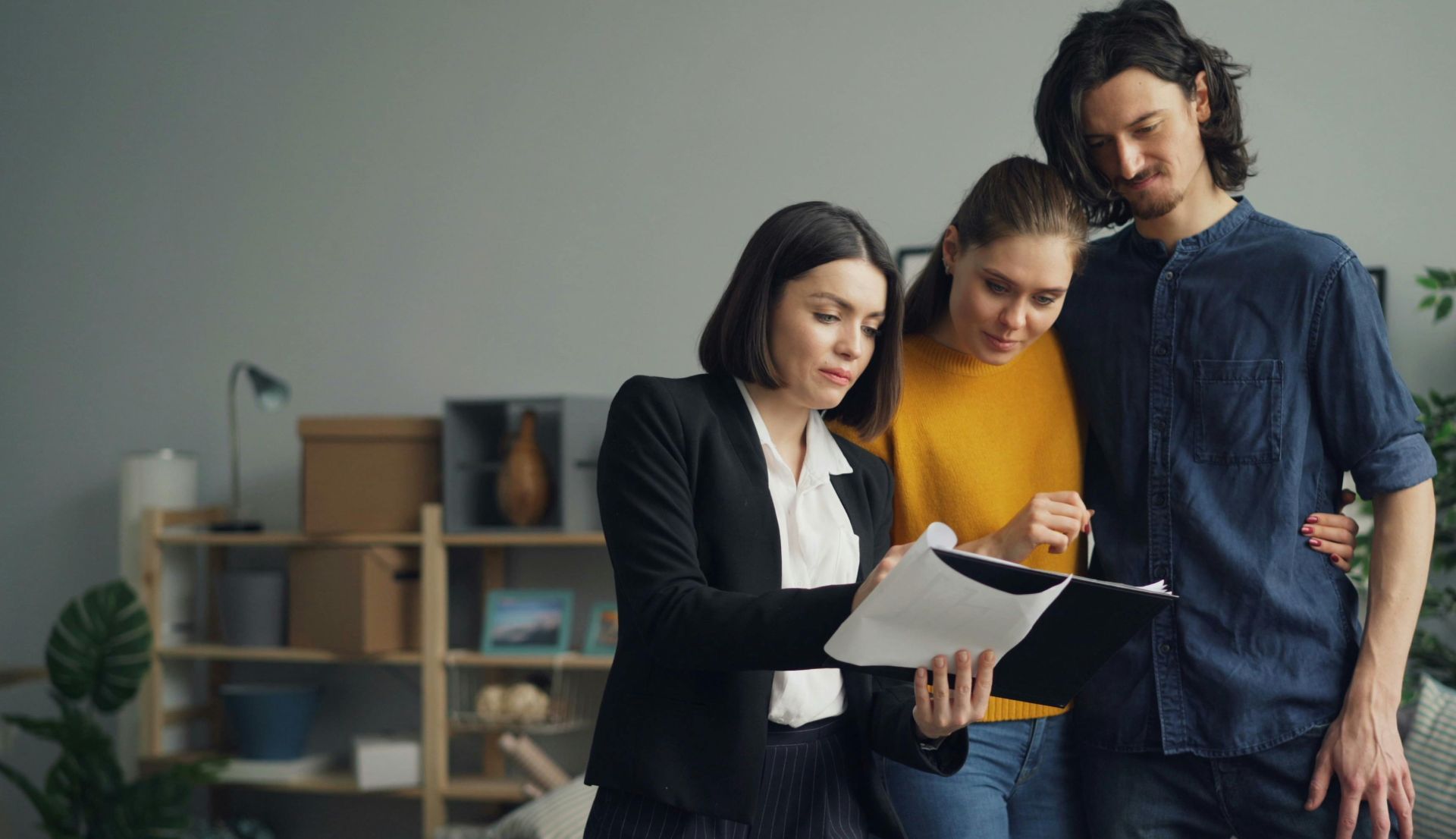 Young couple consulting with a real estate agent about property one indoors.